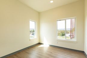 Ellensburg apartment for rent - an empty living room with wood floors and two windows