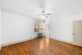 Portland apartment for rent - A room with a ceiling fan and wooden floors.