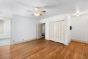 Portland apartment for rent - A room with a ceiling fan and wooden floors.