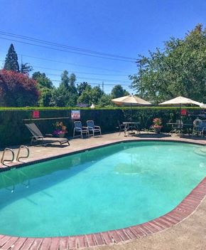 Clackamas apartment for rent - a swimming pool with umbrellas and chairs around it