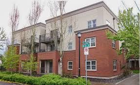 Portland apartment for rent - A building with a red brick facade and a white sign with a green arrow.