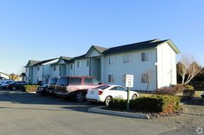 Sunnyside apartment for rent - an apartment building with cars parked in front of it