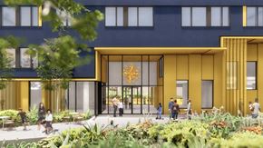 Portland apartment for rent - A modern building with a yellow entrance and people walking around.