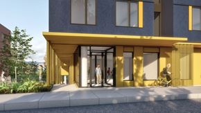 Portland apartment for rent - A modern building with a yellow entrance and people walking in.