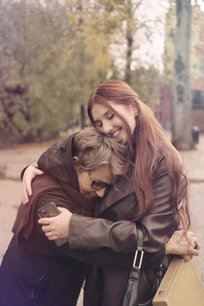 Portland apartment for rent - a girl hugging another girl while looking at a cell phone