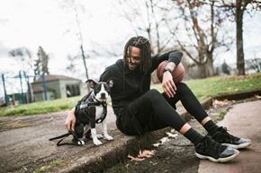 Portland apartment for rent - A man with dreadlocks is sitting on the ground with his dog.