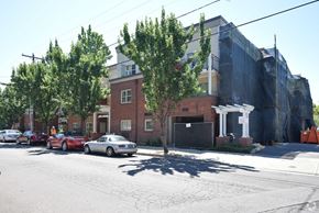 Portland apartment for rent - A red car is parked in front of a brick building.
