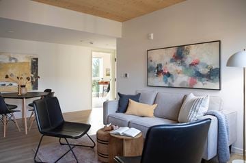 Portland apartment for rent - A living room with a grey couch and a painting on the wall.