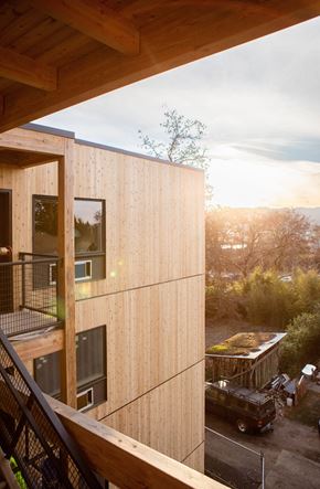 Portland apartment for rent - A modern wooden building with a balcony and a car parked outside.