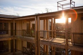 Portland apartment for rent - A wooden balcony with a metal railing and a sunset in the background.