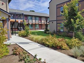 St Helens apartment for rent - a sidewalk in front of a building with trees and grass
