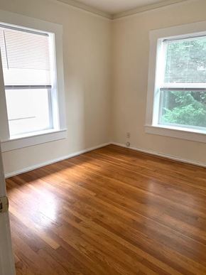 Portland apartment for rent - an empty room with a wooden floor and two windows