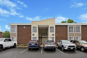 Flemington apartment for rent - A parking lot in front of a building with cars parked.