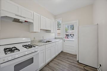 Princeton apartment for rent - A kitchen with white cabinets and a white stove top oven.