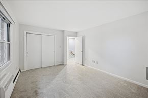Flemington apartment for rent - A spacious room with white walls and carpeted floor.