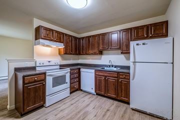 Mercerville apartment for rent - A kitchen with wooden cabinets and a white refrigerator.