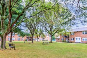 East Windsor apartment for rent - A park with benches and trees in front of apartment buildings.