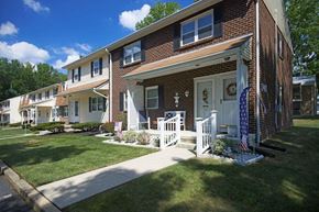 Mercerville apartment for rent - a brick house with a porch and a white fence