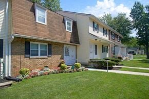 Mercerville apartment for rent - a brick house with a lawn and a sidewalk