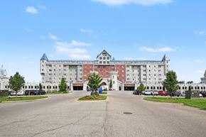 Grandville apartment for rent - A large white building with a red roof and a blue roof.