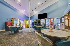Grandville apartment for rent - A room with a table surrounded by chairs and a wall of arcade games.
