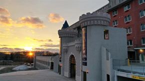 Grandville apartment for rent - the sun sets behind a building with a castle entrance