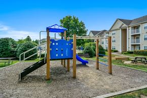 Leesburg apartment for rent - A playground with a blue slide and a wooden structure.