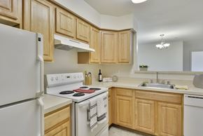 Leesburg apartment for rent - A kitchen with wooden cabinets and white appliances.