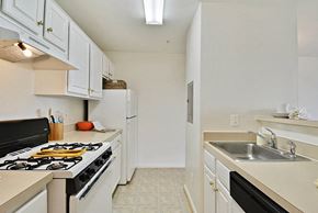 Ashburn apartment for rent - A kitchen with a black stove top oven and white cabinets.