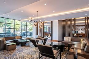 Arlington apartment for rent - A modern living room with a large window and a chandelier.