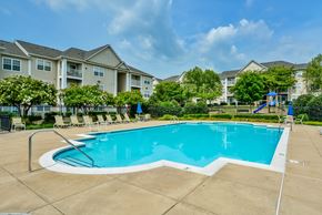 Leesburg apartment for rent - A large swimming pool in front of apartment buildings.
