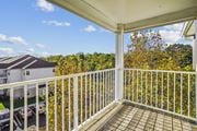 Ashburn apartment for rent - A balcony with a white railing overlooks a parking lot and a building.