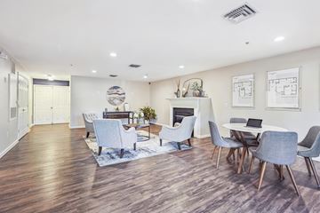 Leesburg apartment for rent - A modern living room with a fireplace and a dining table set up.
