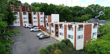 Birmingham apartment for rent - A parking lot in front of a red and white building.