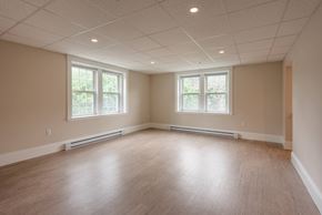 Portsmouth apartment for rent - A spacious room with wooden floors and two windows.