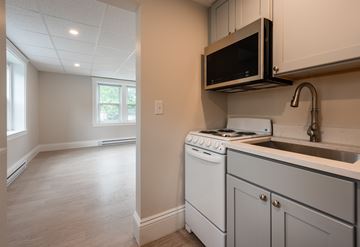 Portsmouth apartment for rent - A kitchen with a white oven and microwave.