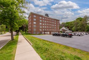 Portsmouth apartment for rent - A large red brick building with a parking lot in front.