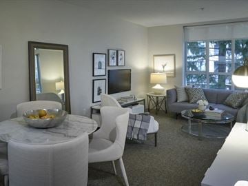 Vancouver apartment for rent - A modern living room with a white chair and a marble table.