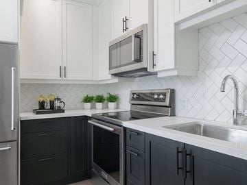 Victoria apartment for rent - A kitchen with black cabinets and a stainless steel oven.
