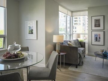 Vancouver apartment for rent - A living room with a glass table and grey chairs.