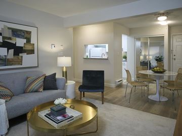 Vancouver apartment for rent - A modern living room with a grey couch, a gold coffee table, and a large painting on the wall.