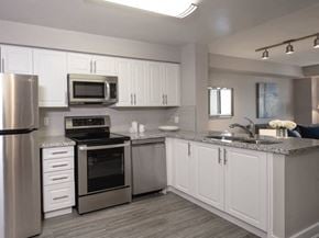 Toronto apartment for rent - a kitchen with white cabinets and stainless steel appliances