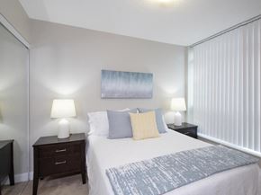 Etobicoke apartment for rent - a bedroom with a large bed and two night stands with lamps