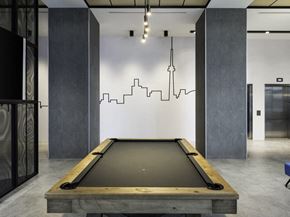 Etobicoke apartment for rent - a pool table sits in the middle of a room with a cityscape painted on the wall