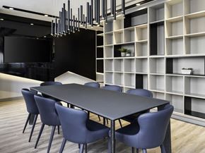 Etobicoke apartment for rent - a long black table with blue chairs in front of a white bookshelf