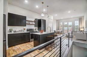 Belmont apartment for rent - a large kitchen with black cabinets and a balcony