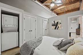 Richmond apartment for rent - a bedroom with a large bed and a closet with a washer and dryer