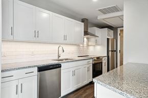 Richmond apartment for rent - A kitchen with white cabinets and a granite countertop.