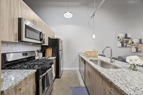 Richmond apartment for rent - kitchen with granite countertops and stainless steel appliances at the flats at big tex apartments in san