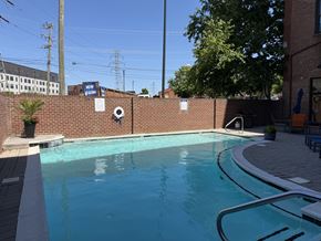 Richmond apartment for rent - A pool with a brick wall and a sign that says "NOW" on it.